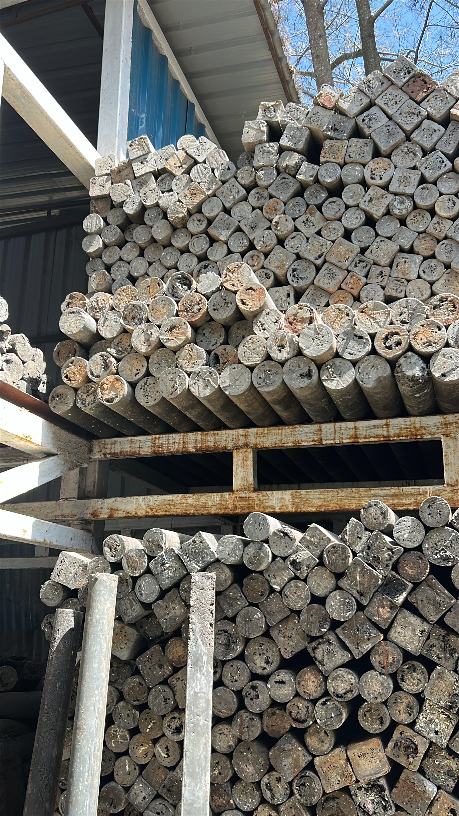 Stacks of finished plastic poles at the Silverlink facility, each cross-section showing the reclaimed plastic from which it was pressed.