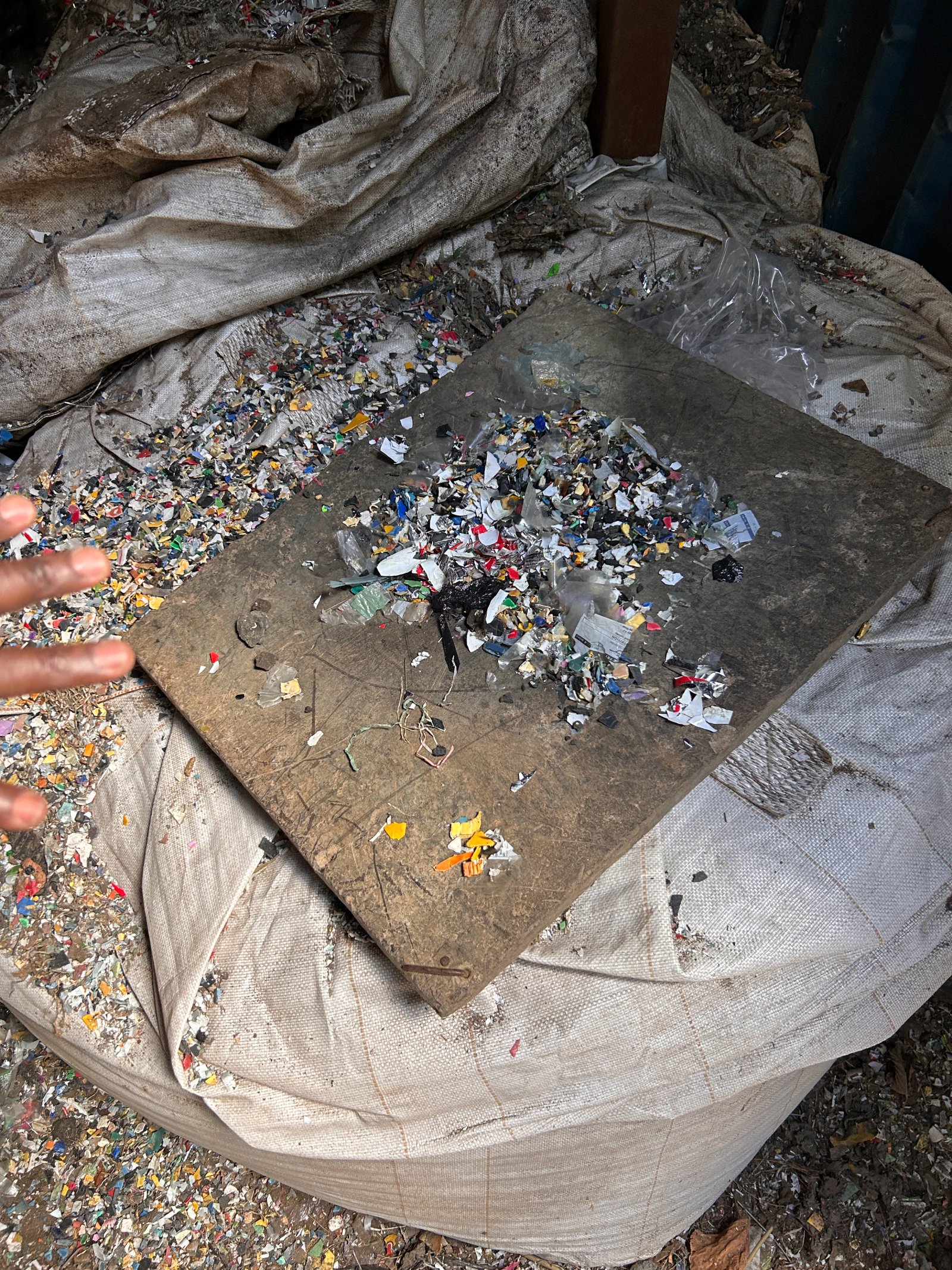 Shredded plastic feedstock spread across a metal plate.