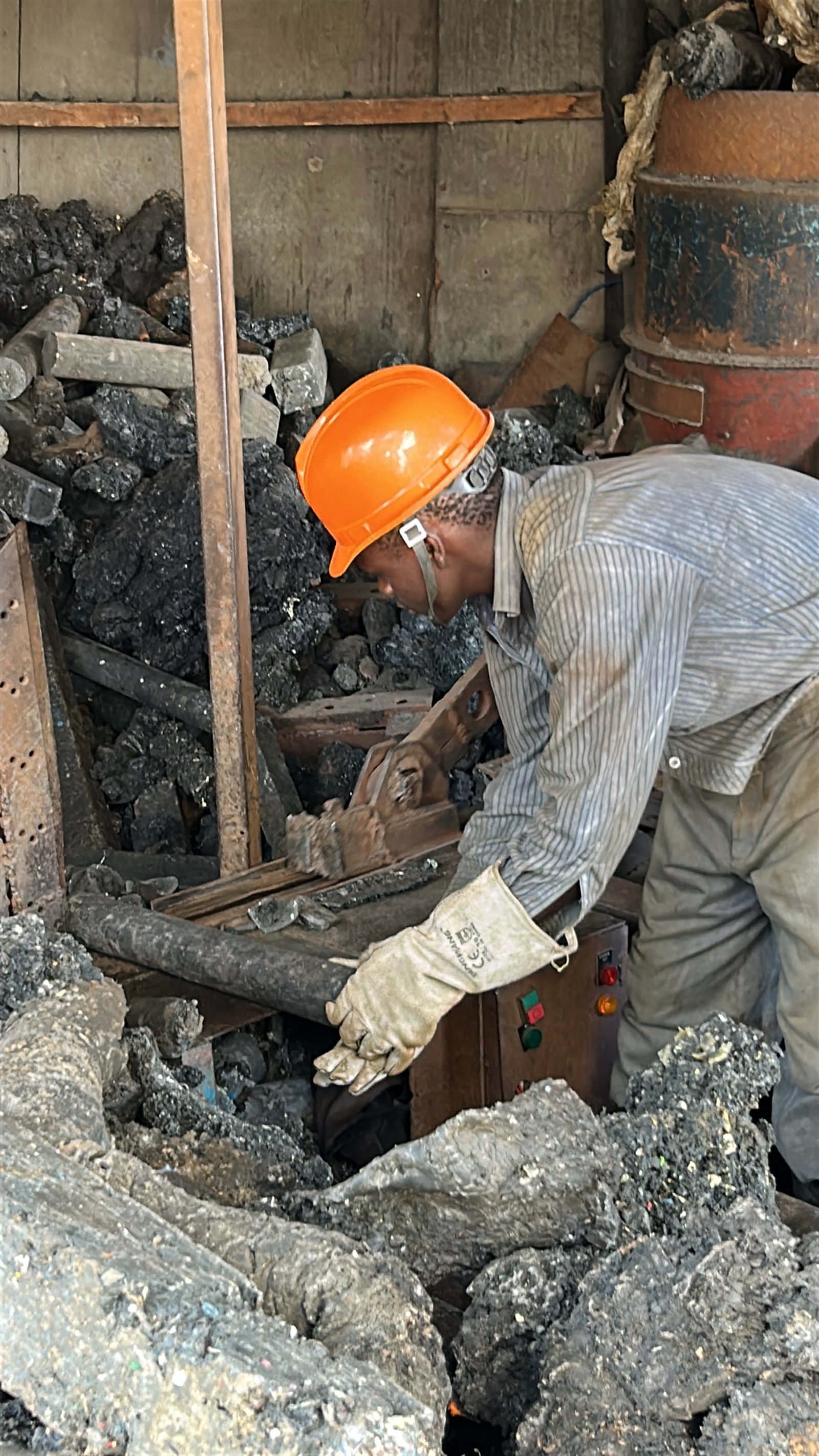 A Silverlink technician in safety gear extracting partially-formed material from a heated press.