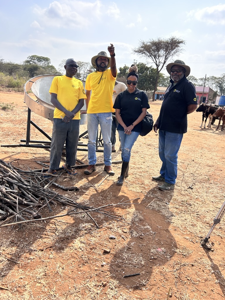 Four members of the Consuming Carbon team and the Farmer Care Cooperative standing beside the loaded Kontiki kiln, ready to begin the first burn.