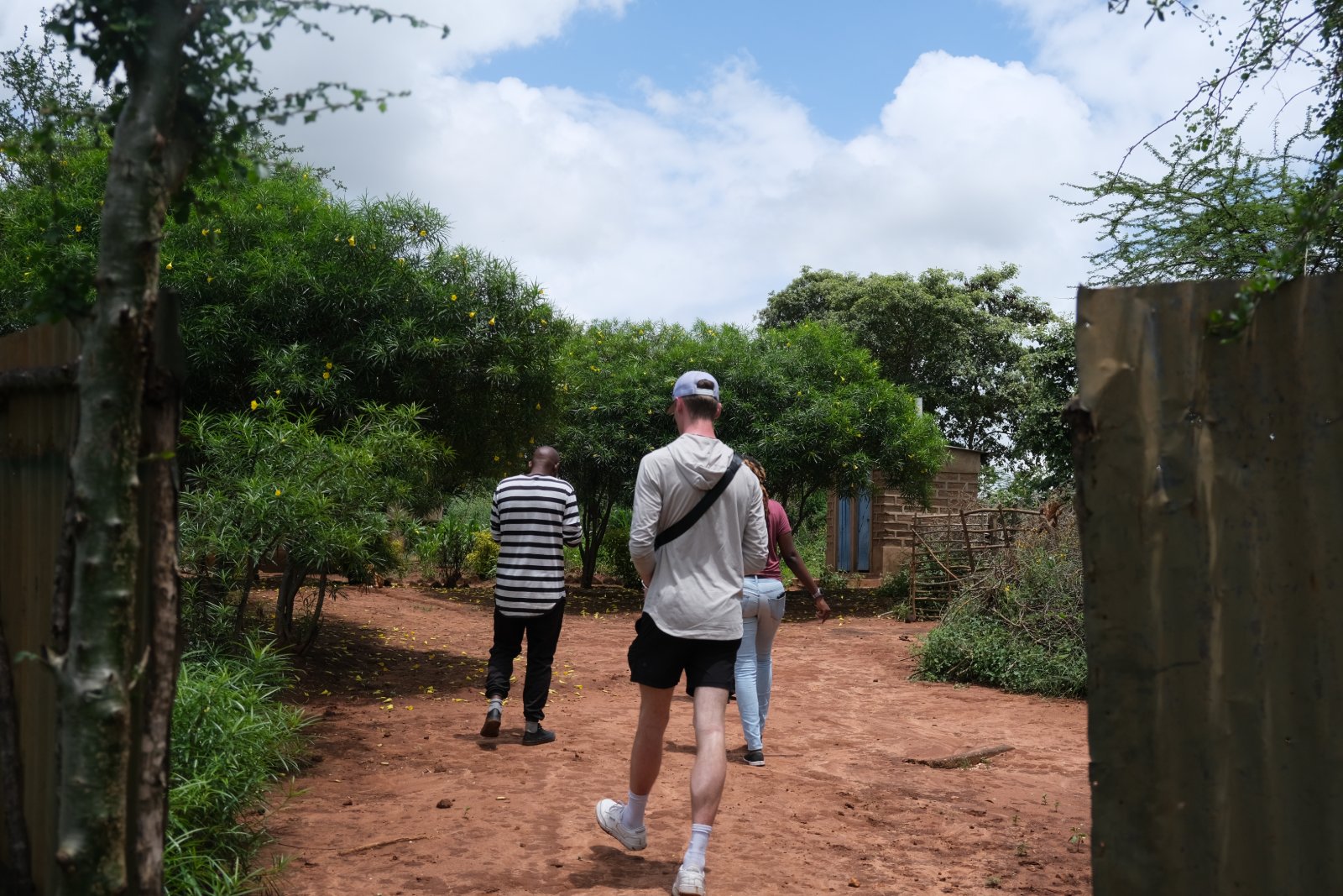 The interns walking into a homestead with the local project developer in Wamunyu.