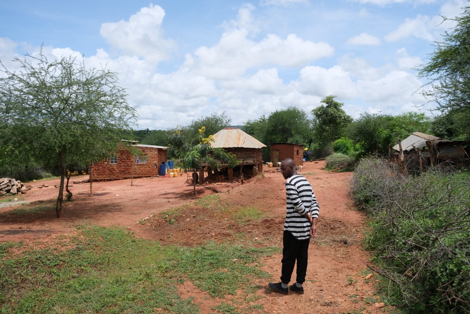 A member of the local team surveying a homestead and outbuildings in Wamunyu.
